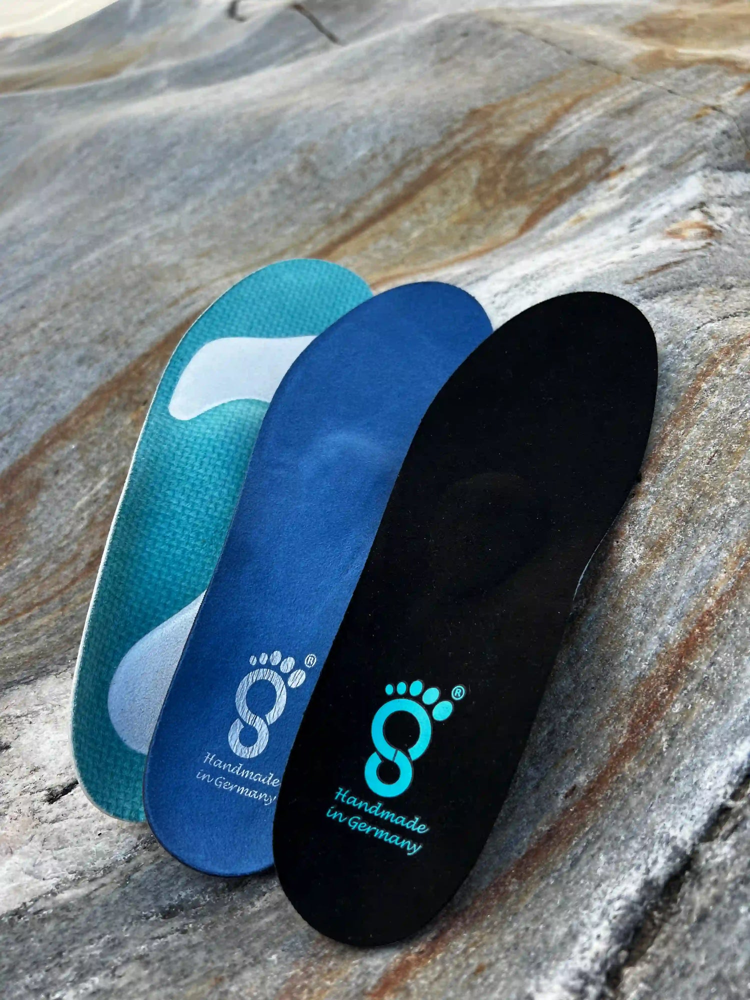 3 insoles leaning on a stone