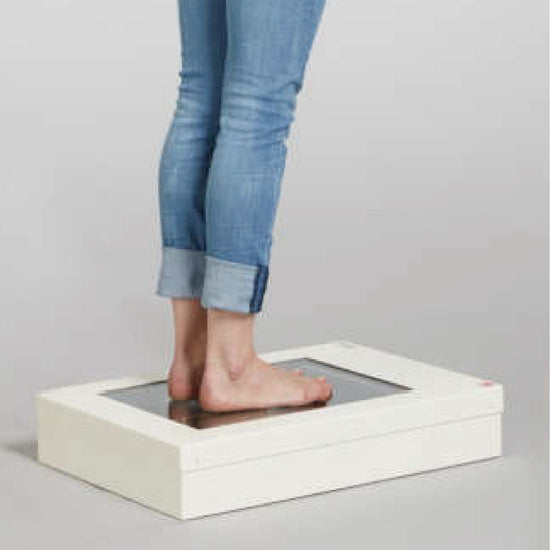 Woman in jeans standing on foot scanner